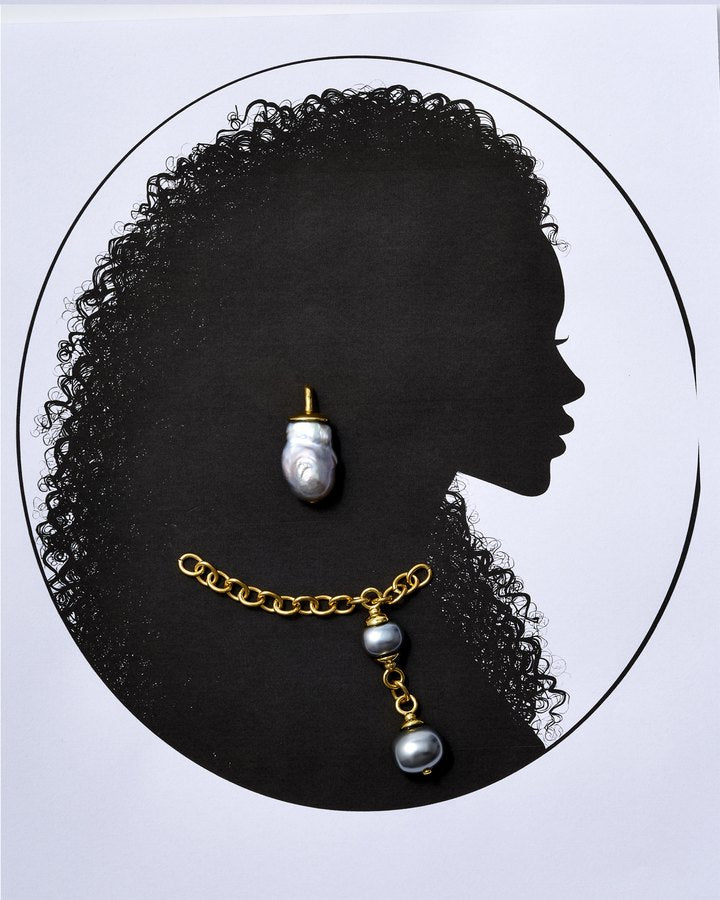 Cameo silhouette with curly hair wearing a baroque pearl earring and gold chain with pearl drops
